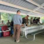 Core Outdoor Living employees enjoy lunch and conversation under a picnic shelter at Burke Lake Park.